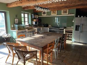 uma cozinha com uma grande mesa de madeira e cadeiras em Spacieux Mas Provençale em Sarrians