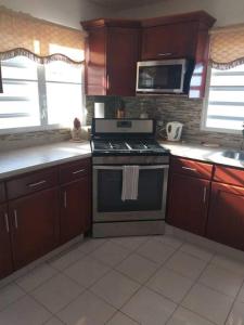 a kitchen with a stove and a microwave at The Garden Apartment in Philipsburg