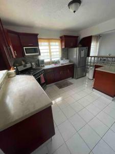 a large kitchen with a stove and a refrigerator at The Garden Apartment in Philipsburg