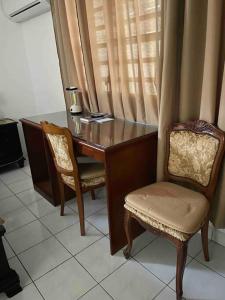a desk with two chairs and a table with a lamp at The Garden Apartment in Philipsburg