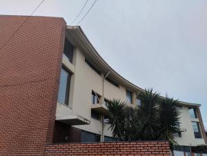 un edificio de ladrillo con una palmera delante de él en Espinho Sweets Suites Martinho, en Espinho