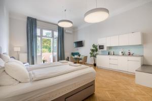 une grande chambre avec un grand lit et une cuisine dans l'établissement Klauzál Garden City Apartments - deluxe studio with Balcony K23, à Budapest