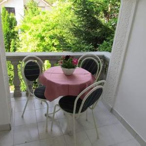 uma mesa e cadeiras numa varanda com uma mesa rosa em Luksuzni Apartmani Mitić-Mint em Sokobanja