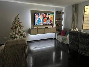 Sala de estar con árbol de Navidad y TV en Espacio para ti y tu familia, en Lima