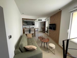 sala de estar con sofá verde y mesa en Appartement Neuf et Design en Camarsac