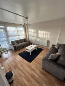 a living room with a couch and a table at 2 Bedrooms. London Skyline view 3 beds and balcony in London