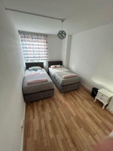 two beds in a small room with a window at 2 Bedrooms. London Skyline view 3 beds and balcony in London
