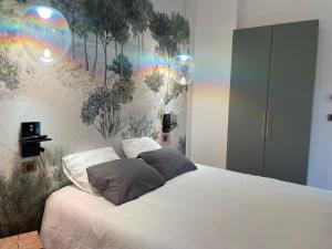 a bedroom with a bed with a rainbow mural on the wall at Appartement Neuf et Design in Camarsac