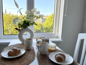 a table with two plates of pastries and a vase at Ilmarise Apartment in Viljandi