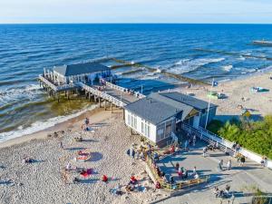 een luchtzicht op een strand met een pier bij Storey holiday cottages, Ustronie Morskie in Ustronie Morskie