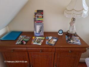 a wooden dresser with magazines and a lamp on it at The Annexe in Bridlington