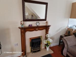 a living room with a fireplace and a mirror at The Annexe in Bridlington