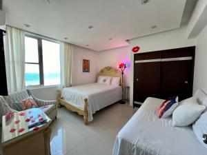 Condado Lux Oceanfront Tantra Ap في سان خوان: غرفة نوم بسريرين وصالة جلوس