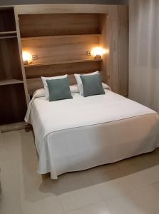 a bedroom with a large white bed with two pillows at Apartamento La Fuente 27 in Tomares