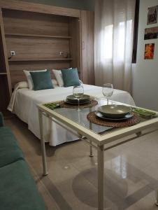 a bedroom with a bed with two glasses on a table at Apartamento La Fuente 27 in Tomares