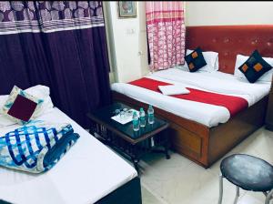 een hotelkamer met 2 bedden en een tafel bij The Super Residency in New Delhi
