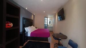 Schlafzimmer mit einem Bett, einem Tisch und Stühlen in der Unterkunft Hotel Real Campestre Tepetoci in Tepexi del Río