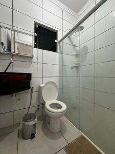 uma casa de banho com um WC e uma cabina de duche em vidro. em Casa de Campo Chácara Divisa Rio Preto e Guapiaçu em Sao Jose do Rio Preto