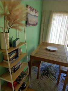 a dining room with a table and a book shelf at Cozy Glamping Cabins in Motueka