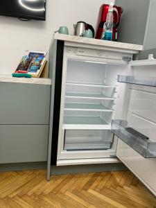 an empty refrigerator with its door open in a kitchen at Style Central in Bucharest