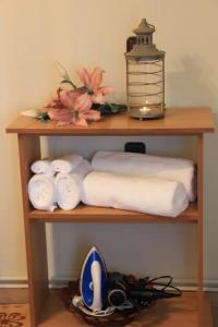 a wooden shelf with rolled towels and a lamp at Theasis home 
