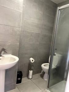 a bathroom with a toilet and a sink and a shower at 4 Bedroom, Spacious House in Harmondsworth