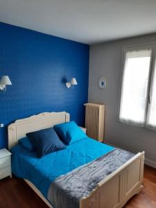 a blue bedroom with a bed with blue sheets at Maison calme entre Loire et Châteaux. in Montlouis-sur-Loire