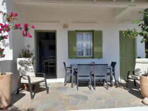 un patio con sillas, una mesa y una ventana en Villa Simeon, en Platis Yialos Sifnos