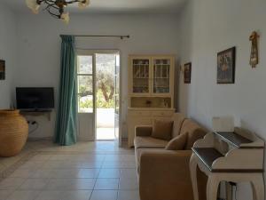 a living room with a couch and a tv at Villa Simeon in Platis Gialos