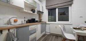 a kitchen with white cabinets and a table and a window at Confort Studio 1 City Center in Bucharest