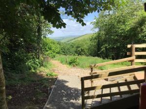 a wooden bench on a dirt path with a view at Fronfetyn in Aberystwyth