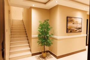um corredor com escadas e uma árvore nele em luxury duplex apartment Alkhobar em Al Khobar