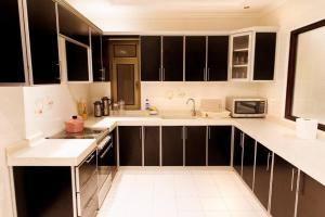 uma cozinha com armários a preto e branco e um lavatório em luxury duplex apartment Alkhobar em Al Khobar