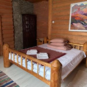 een slaapkamer met een houten bed en handdoeken bij Будинок Художника in Synevyrsʼka Polyana