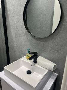 a bathroom with a sink and a mirror at The Boyd - Coorie Doon in Prestwick