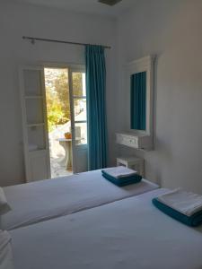 a bedroom with a white bed with a window at Villa Simeon in Platis Yialos Sifnos