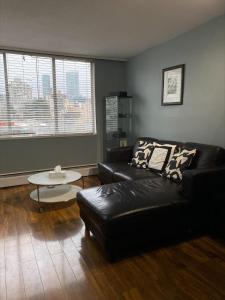 a living room with a black leather couch and a table at Condo in Downtown in Vancouver