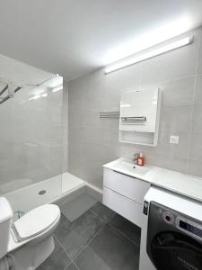 La salle de bains blanche est pourvue de toilettes et d'un lavabo. dans l'établissement Appartement récemment rénové à 1min du métro, à Créteil