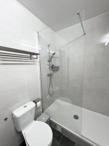La salle de bains blanche est pourvue d'une douche et de toilettes. dans l'établissement Appartement récemment rénové à 1min du métro, à Créteil