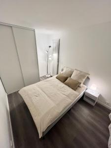 - une chambre dotée d'un grand lit avec des draps et des oreillers blancs dans l'établissement Appartement récemment rénové à 1min du métro, à Créteil
