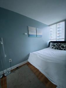1 dormitorio con cama blanca y ventana en Condo in Downtown en Vancouver