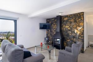a living room with a stone wall with a fireplace at Villa La Graja by Huskalia - private pool in Los Llanos de Aridane