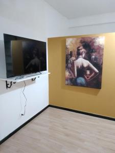 a room with a television and a painting on the wall at Red_Cross.Rent_Appartament in Palermo