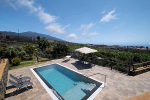 a swimming pool with a view of the ocean at Villa La Graja by Huskalia - private pool in Los Llanos de Aridane