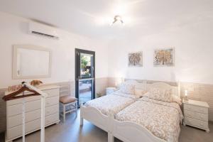 1 dormitorio con cama blanca y vestidor en Villa La Graja by Huskalia - private pool, en Los Llanos de Aridane