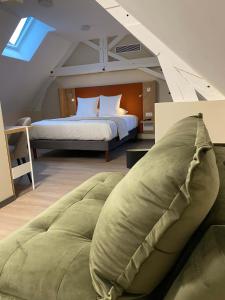 een slaapkamer met een groot bed op zolder bij Hôtel du Commerce-restaurant au Couteau in Nogent