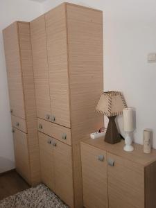 a bedroom with wooden cabinets and a lamp on a dresser at Apartament Velana in Reşiţa