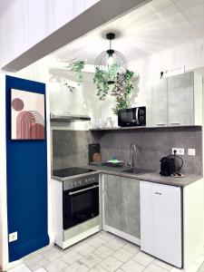 una cocina con armarios blancos y una puerta azul en Design 3 bedroom near Main Train Station Apartment, en Viena