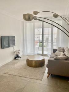 sala de estar con sofá, mesa y lámpara en Majestic Apartment, en Cannes