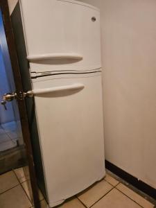 a white refrigerator in a corner of a room at cerca aeropuerto tobias bolaños in San José